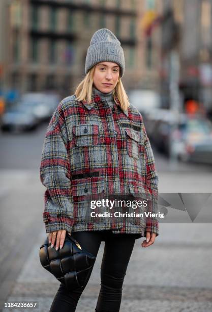 Sonia Lyson is seen wearing black pants Zara, cashmere turtleneck, Bottega Veneta bag, grey red plaid jacket Lala Berlin, grey beanie Acne on October...