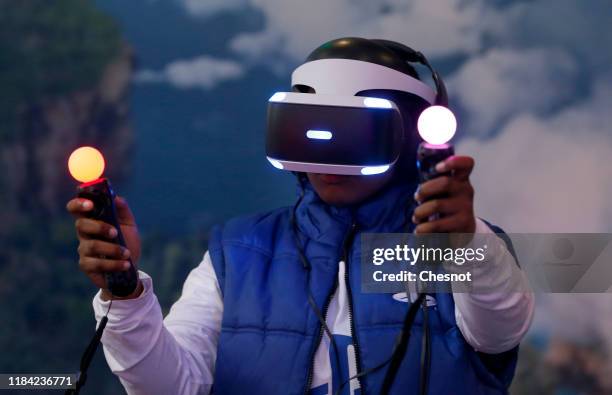 Man plays a video game with a virtual reality head-mounted headset "PlayStation VR" developed by Sony Interactive Entertainment during the 'Paris...