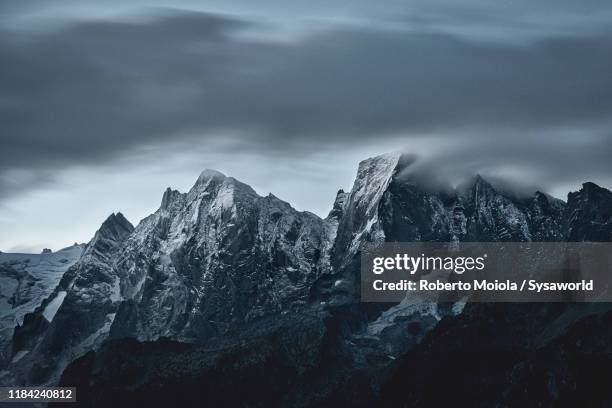 dramatic sky on piz badile and cengalo, tombal, switzerland - extremlandschaft stock-fotos und bilder