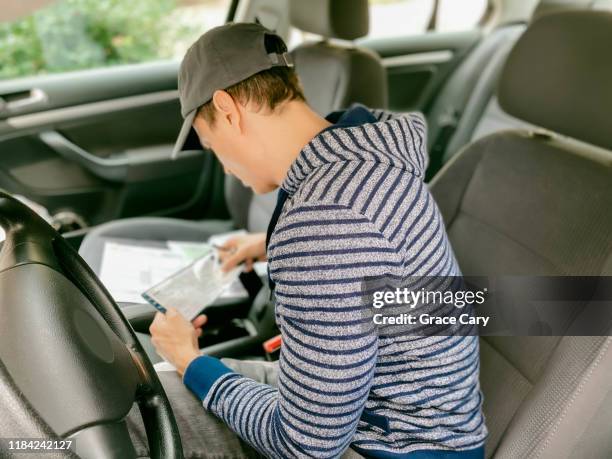 man reads paperwork in car - vehicle registration foto e immagini stock