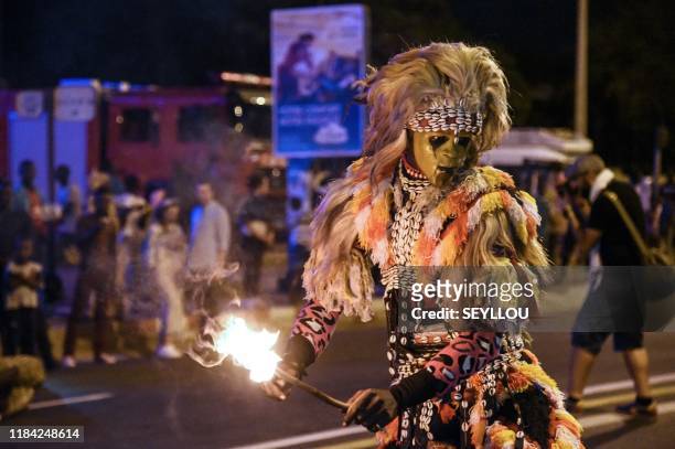 Revellers performing the fake lion game take part in the first edition of the Grand Carnaval of Dakar on November 23 in Dakar. - The carnival running...
