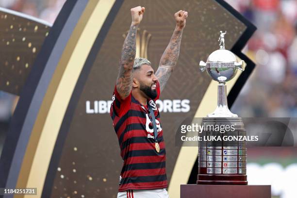 Flamengo's Gabriel Barbosa celebrates next to the trophy after winning the Copa Libertadores final football match by defeating Argentina's River...