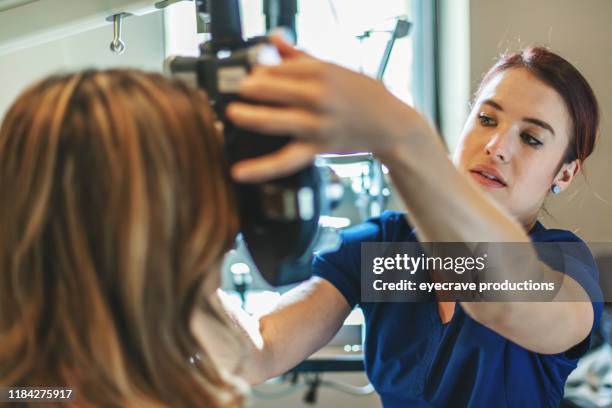 eyecare professional using high tech equipment in eyecare clinic setting part of series with millennial male and female patient in western colorado - eye test stock pictures, royalty-free photos & images