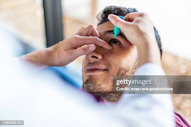eyecare professional using high tech equipment in eyecare clinic setting part of series with millennial male and female patient in western colorado - eye drop stock pictures, royalty-free photos & images