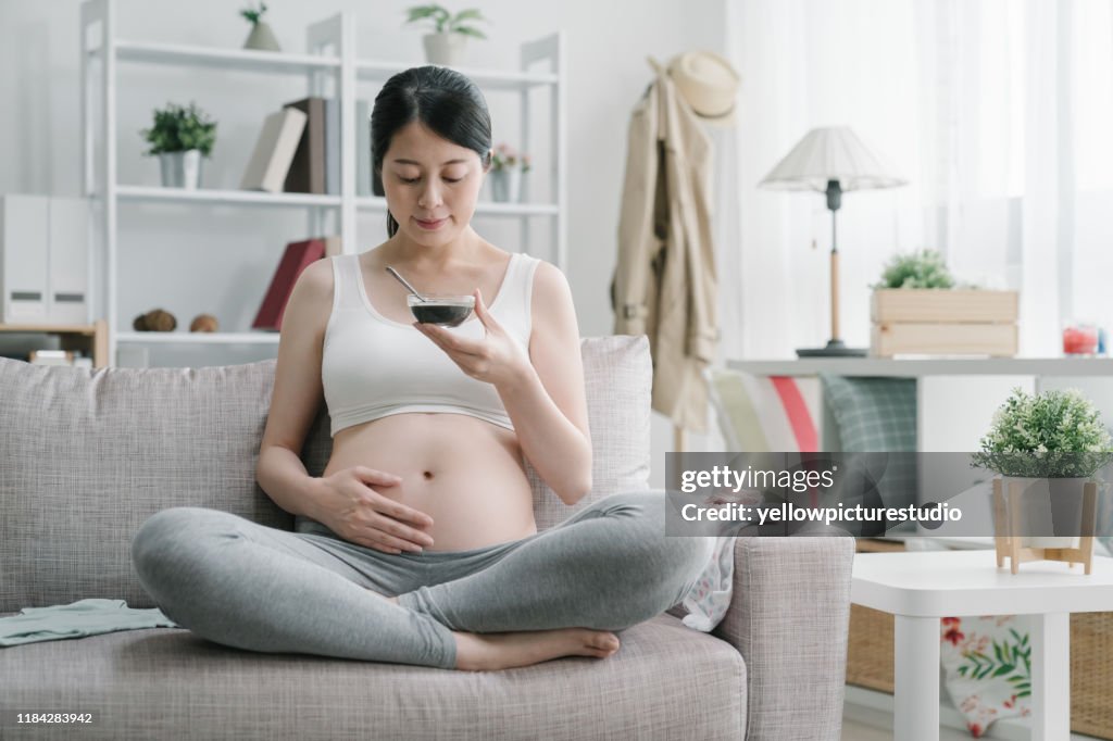 Pregnant woman drinking medicinal cuisine at home