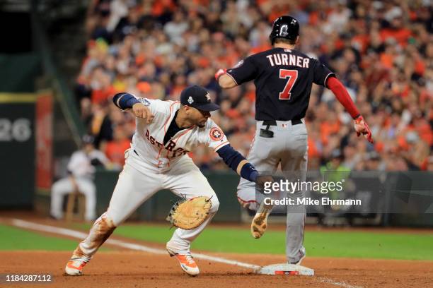 Trea Turner of the Washington Nationals is called out on runner interference for colliding with Yuli Gurriel of the Houston Astros during the seventh...