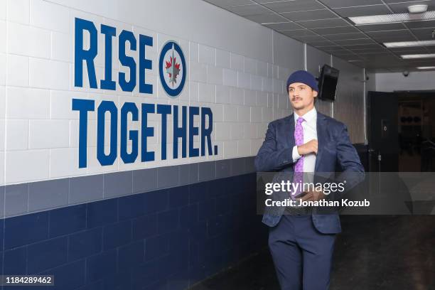 Luca Sbisa of the Winnipeg Jets arrives at the arena sporting a lavender tie in support of Hockey Fights Cancer Night prior to NHL action against the...