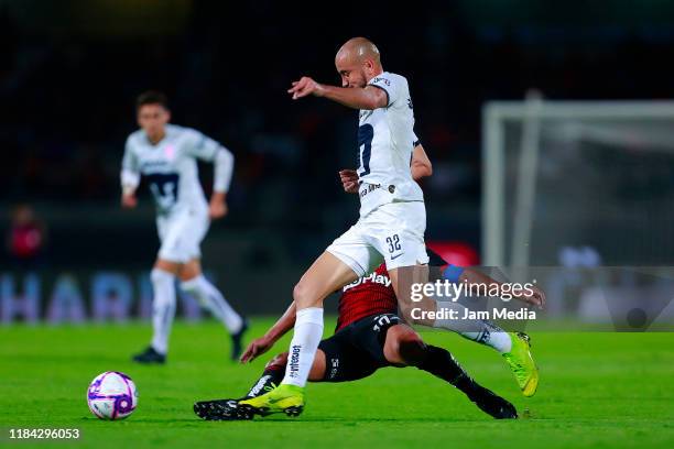 Carlos Gonzalez of Pumas fights for the ball with Osvaldo Martinez of Atlas during the 16th round match between Pumas UNAM and Atlas as part of the...