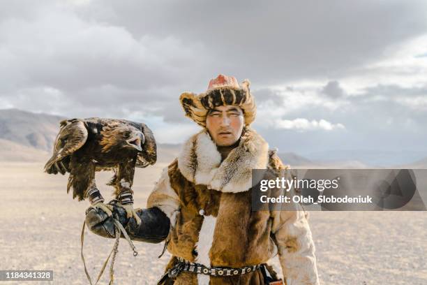 retrato de cazador de águilas de pie en el desierto en mongolia - cetrería fotografías e imágenes de stock