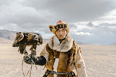 Portrait of eagle hunter standing in desert in Mongolia