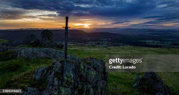 schwert im stein im morgengrauen - swords stock-fotos und bilder