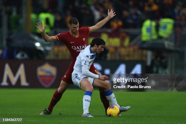 Edin Dzeko of AS Roma competes for the ball with Sandro Tonali of Brescia Calcio during the Serie A match between AS Roma and Brescia Calcio at...