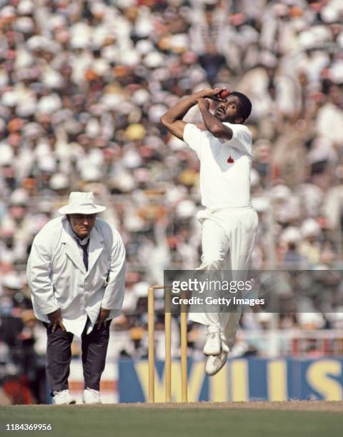 West Indies pace bowler Michael Holding in action as umpire Swaroop Kishen looks on during a Test Match against India in December 1983 in India.