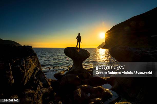 man at sunset on kannesteinen rock, vagsoy, norway - olden foto e immagini stock