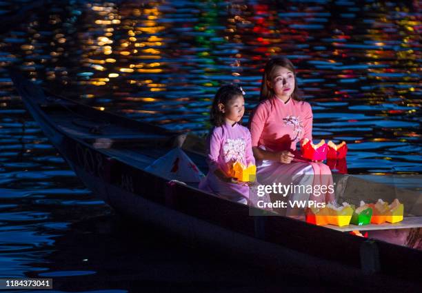 Vietnamese mother and daughter holding Lanterns before droping them into the River in Hoi An Vietnam