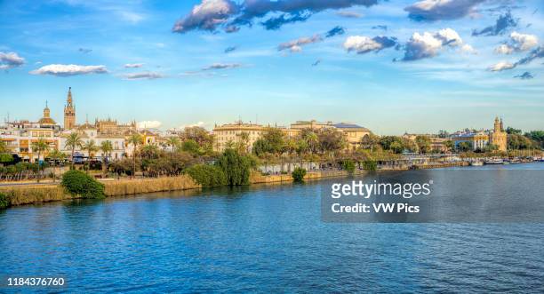 Guadalquivir river east bank from the Triana bridge, with the Giralda tower and Golden Tower among other landmarks. Seville, Spain.