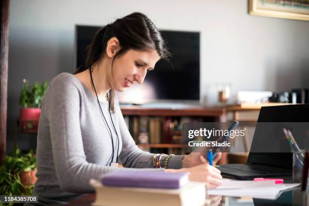 young woman designer working at home - hearing loss at work stock pictures, royalty-free photos & images