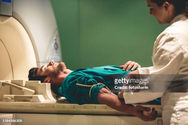 doctor giving injection to patient before mri scan - needle injury stock pictures, royalty-free photos & images
