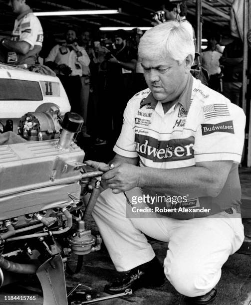 Veteran NASCAR driver and car owner Junior Johnson works on an engine in the speedway garage prior to the running of the 1985 Daytona 500 stock car...