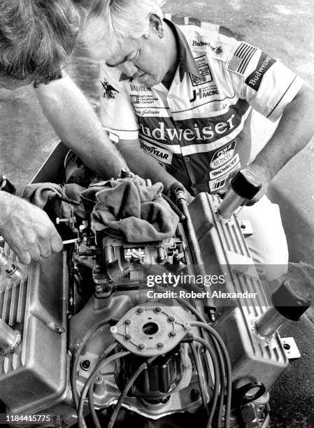 Veteran NASCAR driver and car owner Junior Johnson works on an engine in the speedway garage prior to the running of the 1985 Daytona 500 stock car...