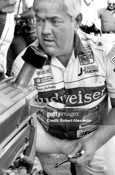 Veteran NASCAR driver and car owner Junior Johnson works on an engine in the speedway garage prior to the running of the 1985 Daytona 500 stock car...