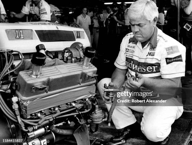 Veteran NASCAR driver and car owner Junior Johnson works on an engine in the speedway garage prior to the running of the 1985 Daytona 500 stock car...