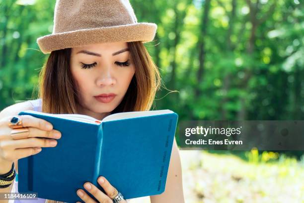 Portrait Of Female Asian Student Reading Note Book At University Campus ...