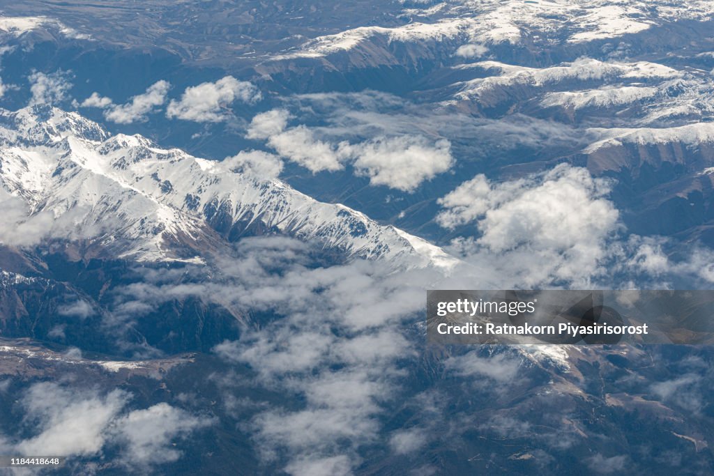 Beautiful sandstone Himalayan mountains with snow in summer season, Clouds and snow mountain, seen from airplane