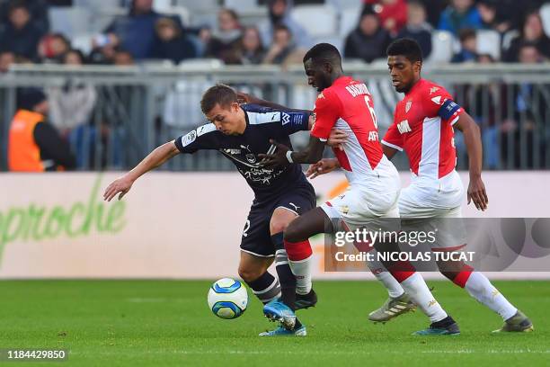 Bordeaux's French forward Nicolas De Preville controls the ball as he is tackled by Monaco's defenders during the French L1 football match between FC...