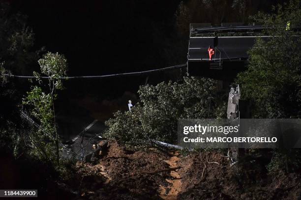 Rescuer stands on the remains of a viaduct section of the A6 highway between Turin and Savona, after it collapsed following a landslide near Savona...