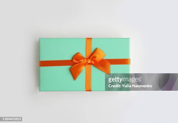 mint color gift box with orange ribbon on white background. isolate, copy space. - present box imagens e fotografias de stock