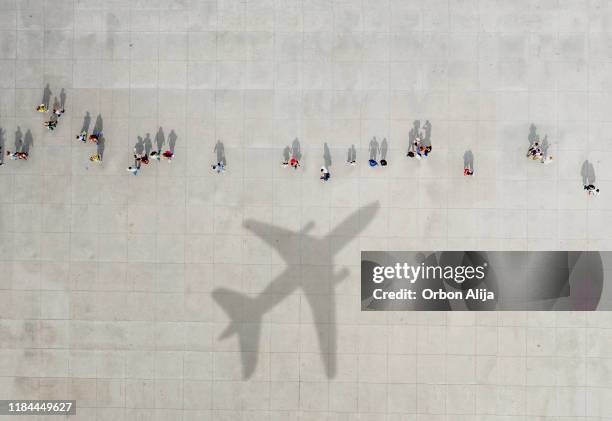 aerial view of crowd with airplane shadow - airport aerial imagens e fotografias de stock