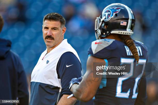 Head Coach Mike Vrabel talks with Derrick Henry of the Tennessee Titans on the field during warm ups before a game against the Jacksonville Jaguars...