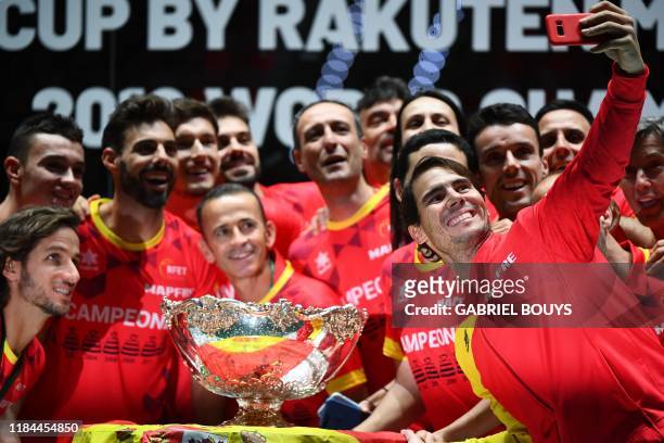 Spain's Rafael Nadal takes a selfie photo posing with teammates and the winner's trophy during the trophy ceremony after winning the Davis Cup Madrid...