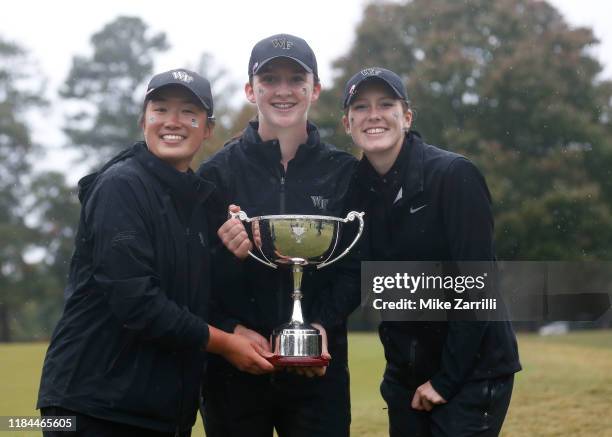 Emilia Migliaccio , Siyun Liu and Lauren Walsh of the Wake Forest Women's Golf Team celebrate with the East Lake Cup after defeating the Auburn...