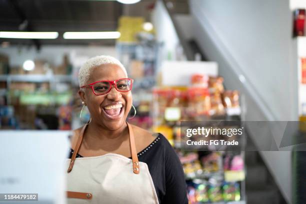 glückliche kassiererin arbeitet im großhandel - clerk stock-fotos und bilder