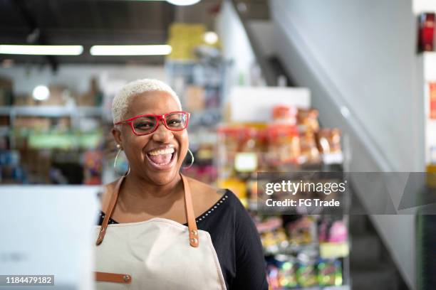 cajero feliz trabajando al por mayor - tienda del vecindario fotografías e imágenes de stock