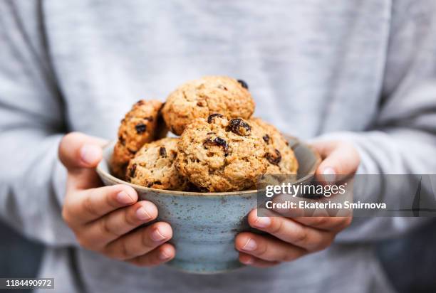 homemade freshly baked oatmeal cookies in kid`s hands - baked goods stockfoto's en -beelden