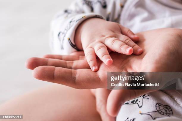 baby hand on mother hand - newborn hand stock pictures, royalty-free photos & images