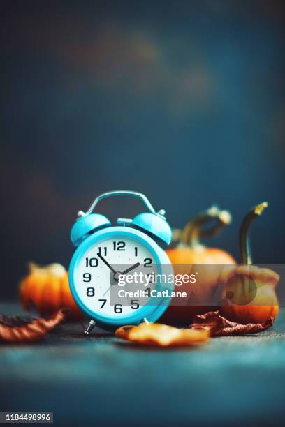 time for fall. alarm clock with leaves and pumpkins. daylight savings time. - orange alarm clock stock pictures, royalty-free photos & images