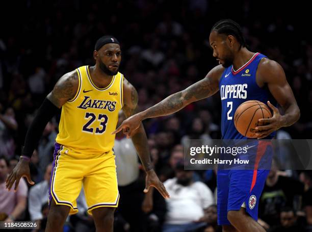 Kawhi Leonard of the LA Clippers controls possession of the ball in front of LeBron James of the Los Angeles Lakers late in the fourth quarter in a...