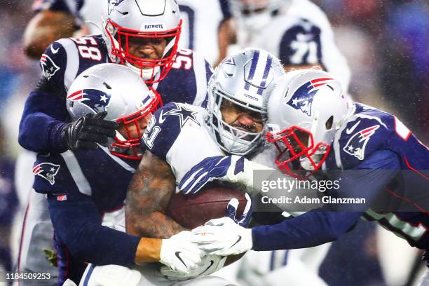 Ezekiel Elliott of the Dallas Cowboys is tackled during a game against the New England Patriots at Gillette Stadium on November 24, 2019 in...