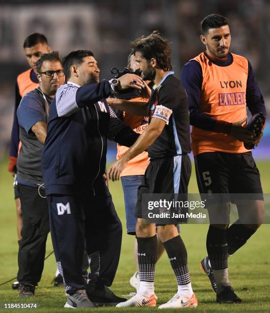 Diego Maradona coach of Gimnasia y Esgrima greets Emiliano Papa of Arsenal at the end of the first half during a match between Gimnasia y Esgrima La...