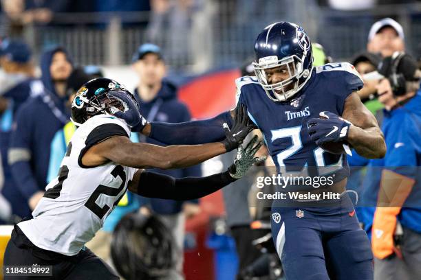 Derrick Henry of the Tennessee Titans runs for a touchdown in the second half and stiff arms Jarrod Wilson of the Jacksonville Jaguars at Nissan...