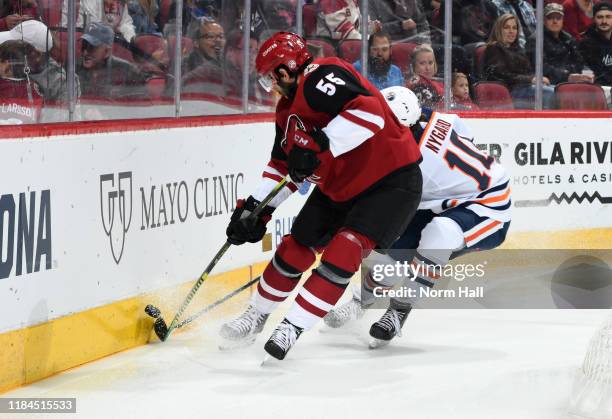 Jason Demers of the Arizona Coyotes and Joakim Nygard of the Edmonton Oilers battle for the puck along the boards during the first period at Gila...