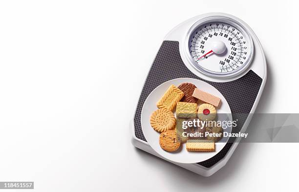 biscuits on bathroom scales with copy space - body conscious stock pictures, royalty-free photos & images
