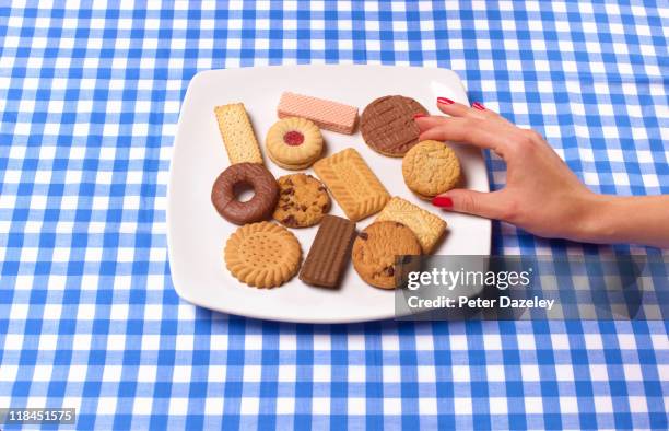 hand removing biscuit from plate - cookie studio stock pictures, royalty-free photos & images