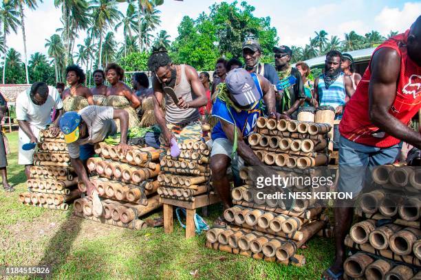 Musicians play bamboo pipes as people queue to vote at a polling station in the capital Buka in an historical independence vote on November 25, 2019....