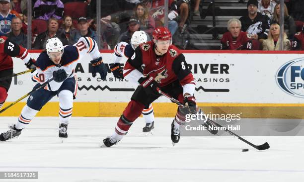 Jakob Chychrun of the Arizona Coyotes advances the puck up ice ahead of Joakim Nygard of the Edmonton Oilers during the second period at Gila River...