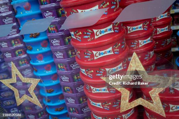 Display of assorted chocolate and sweet boxes of Nestle Quality Street, Cadburys Roses and Heroes plus Mars Celebrations piled up in the Christmas...